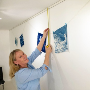 Gail Neumann hanging the 'Under the southern sun' cyanotype exhibition at The Maud Street Photo Gallery